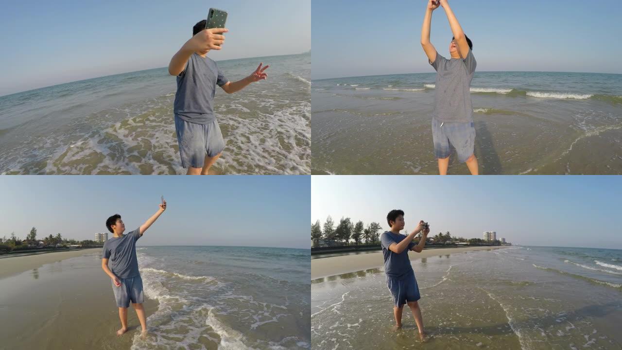 快乐的亚洲男孩在阳光明媚的日子里在海滩上自拍，生活方式理念。