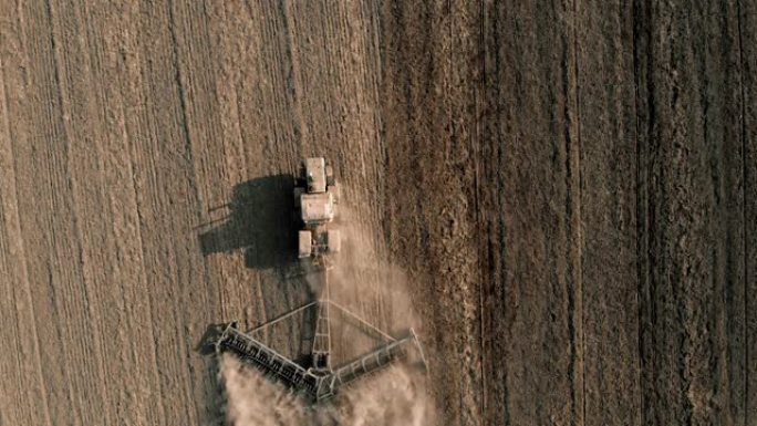 带耕作工具的鸟瞰图大型拖拉机在农场耕种土地