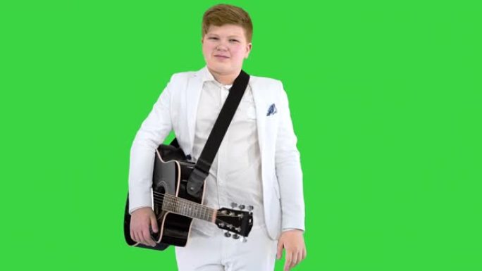 穿着白色西装的男孩，在绿色屏幕上向吉他打招呼，色键
