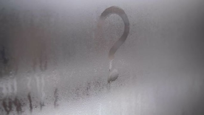 用手指在窗户上画一个问号。窗户起雾了。在阴沉的日子里，在窗户的湿玻璃上画画，在家中隔离。灰色4k