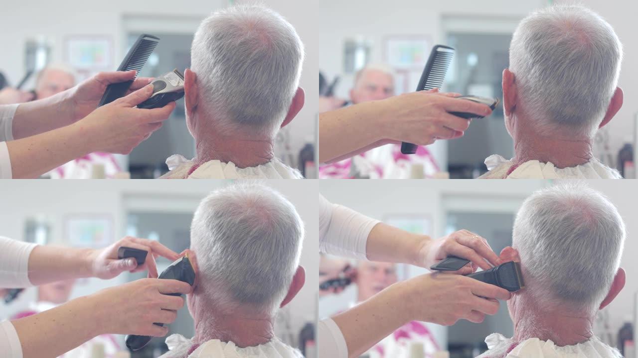 美发师用电动剃须刀将高级男士剃在耳朵后面