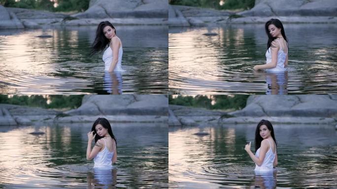 美丽的黑发女孩，长发站在水中。慢动作。