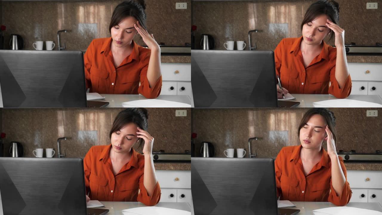 一名年轻女子在笔记本电脑上工作，患有头痛和乏力。