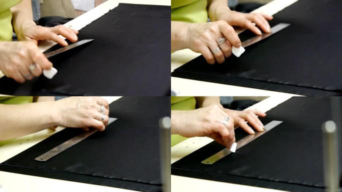 裁缝师在缝制优质织物并制作一件高级时装之前，先将其切成黑色。女裁缝的手在工作。传统观念、工业和时尚。