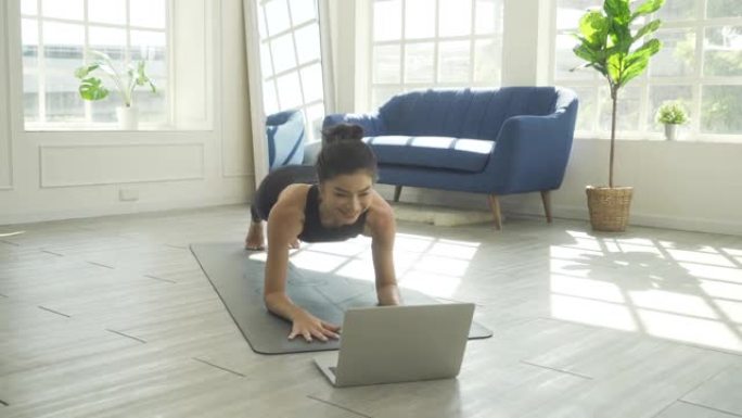 在家练习瑜伽，在笔记本电脑上看辅导课