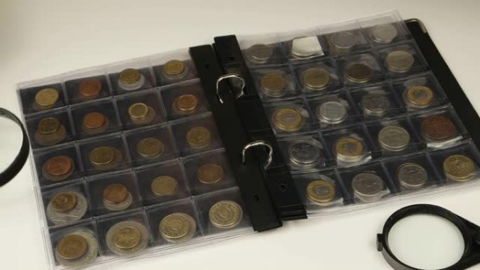 硬币收藏家将硬币放入硬币文件夹中