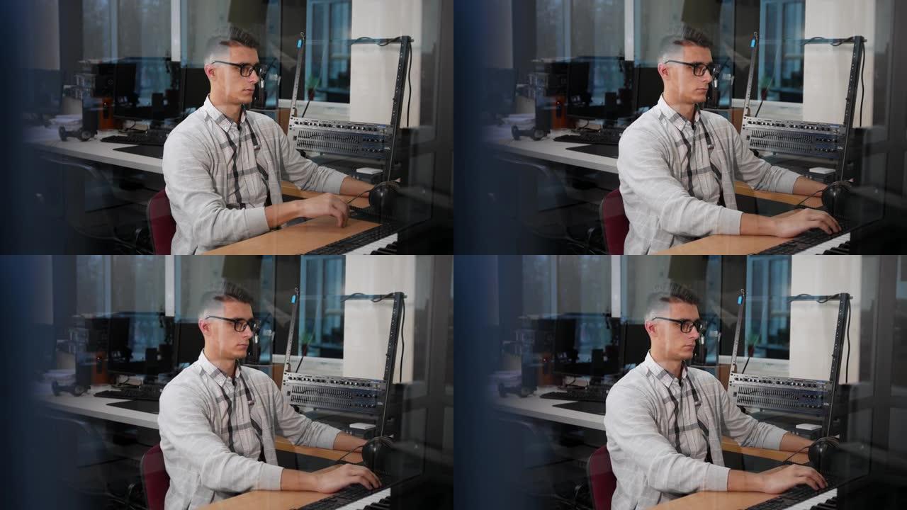 戴眼镜的年轻人在办公室的工作场所在计算机上工作