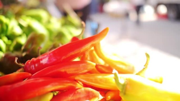 慢镜头拍摄了一只从当地农贸市场采摘红辣椒的女性手