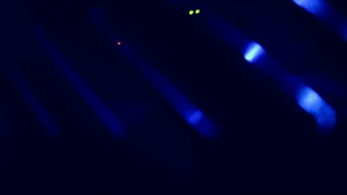 黑暗中的服务器室。蓝光透过服务器机架的网格。