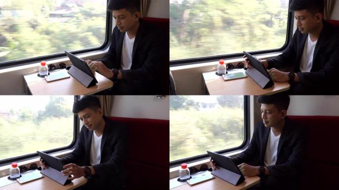 亚洲商人在火车上使用移动智能手机和数字平板电脑