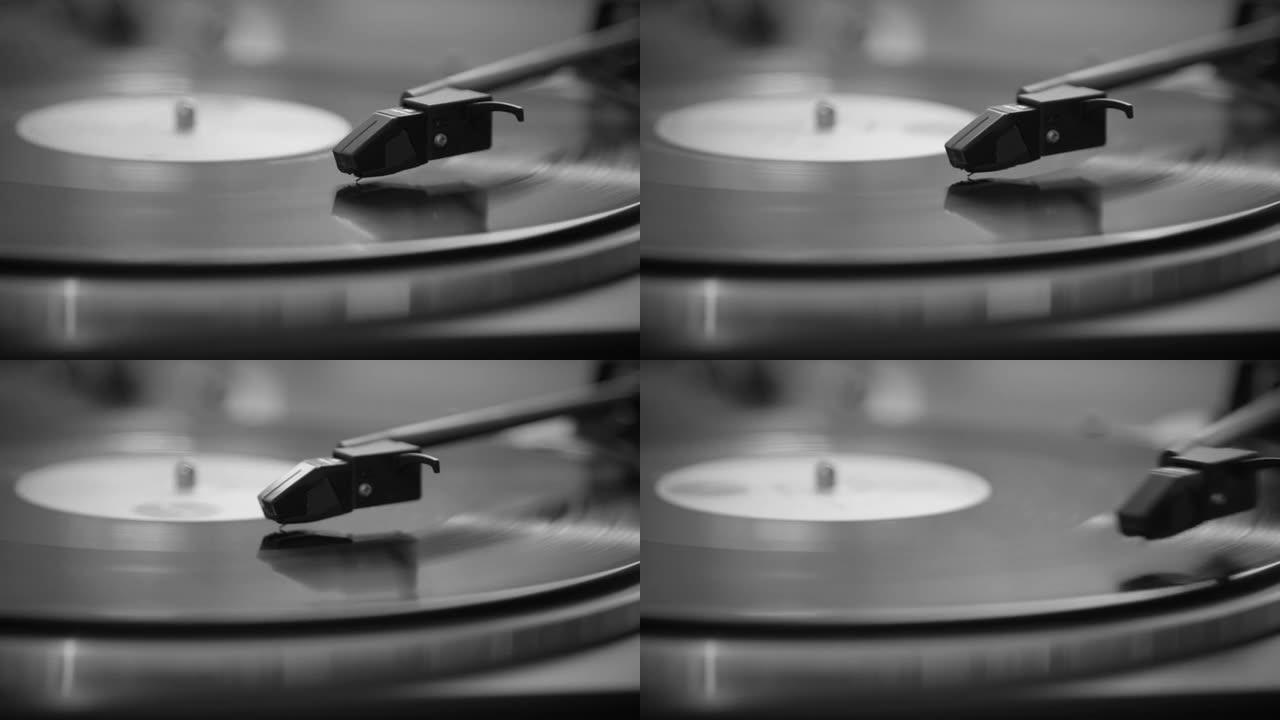 黑白相间。针从老式的黑胶唱片中升起。黑胶唱片已经停止。黑胶唱片正在旋转。针在老式黑胶唱片上播放。旧转