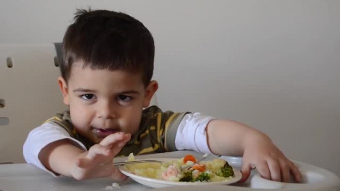 脾气暴躁的两岁男孩玩食物拒绝吃东西
