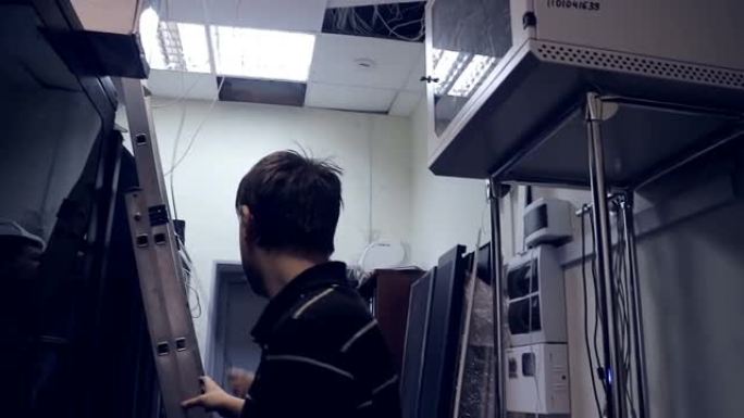 服务器机房的工作人员。电子工程师正在寻找一个错误。天花板上的房间里装满了设备、垃圾、电线