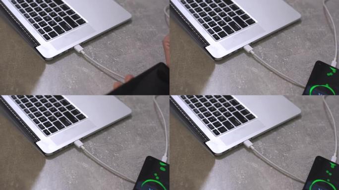 用手将充电器插入笔记本电脑的手机