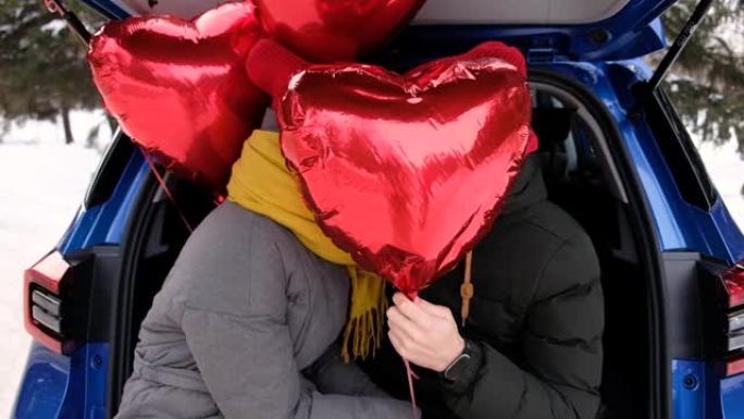 情人节，可爱的男人和快乐的女孩接吻，躲在心形气球后面。情人节庆典，浪漫关系，真诚的感情和爱情概念。幸