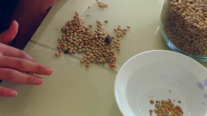 试图清除桌子上的扁豆，提取绿色扁豆，清洁桌子上的绿色扁豆，