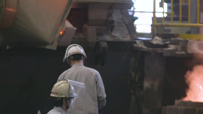 一个人在机器上工作 一个穿灰色衣服的男人在炼制 机械高温炼制