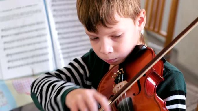 8岁的男孩正在拉小提琴。