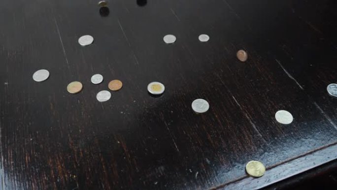 金旧硬币正落在桌子上。旧古董硬币落在木头背景上。商业金融经济概念