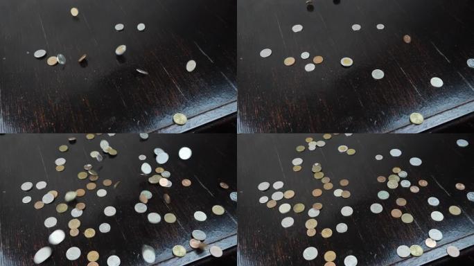 金旧硬币正落在桌子上。旧古董硬币落在木头背景上。商业金融经济概念