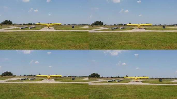 带螺旋桨的黄色飞机在机场的轨道上，螺旋桨正在工作，后视图