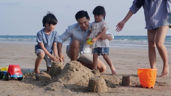 亚洲家庭一起在海滩玩玩具。家庭、假期和旅行概念。