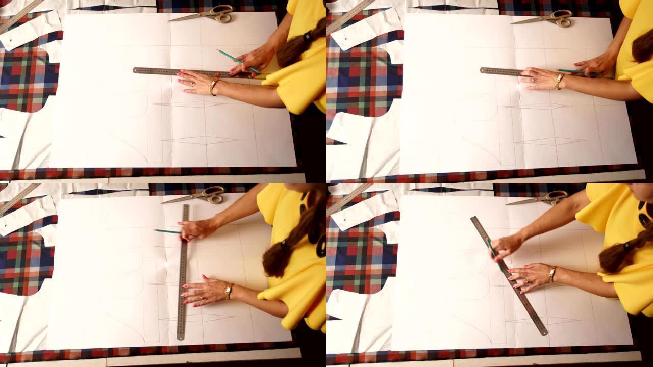 在工作室工作的时装设计师女性双手的近距离观察。高加索女裁缝用铅笔和尺子在布上绘制衣服的布局。室内工作