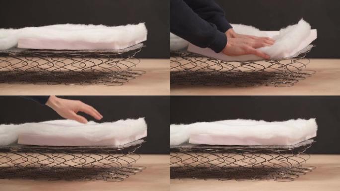 一个专业工厂工人检查床垫弹簧灵活性的演示视频。床垫线圈覆盖有泡沫芯和纤维包裹