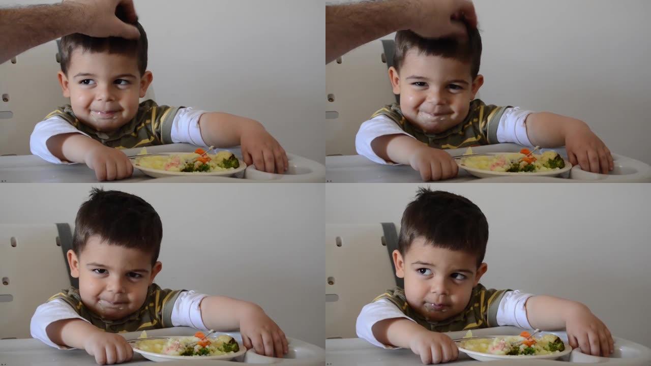 父亲拥抱脾气暴躁的两岁男孩，拒绝吃饭。