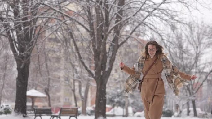 宁静的女人在下雪时奔跑，玩得很开心