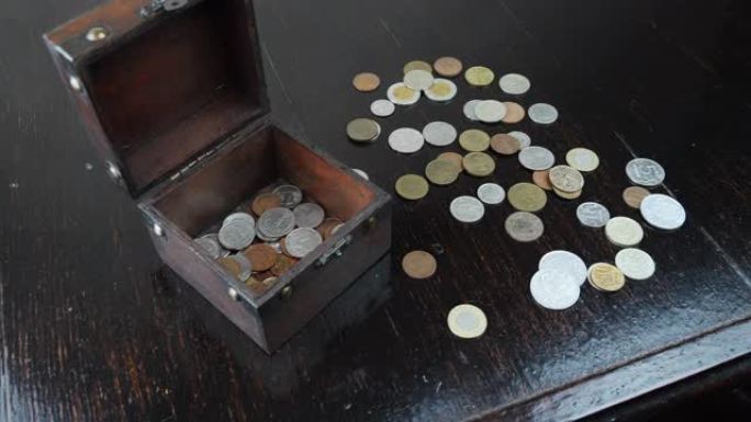 硬币落在木桌上。旧古董硬币落在一堆钱上，特写。掉落的欧元硬币。经济商业概念