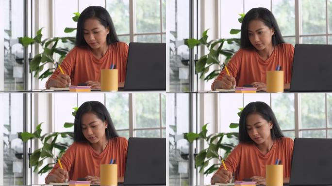 亚洲女性内容创建者在笔记本上写内容并在家工作。计划营销，计划计划者项目计划