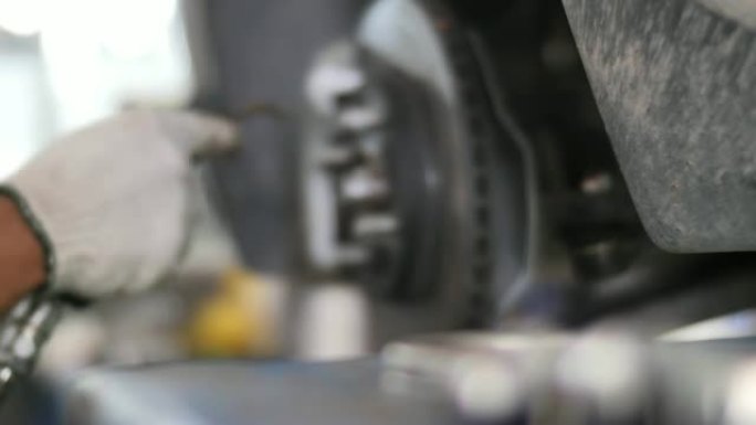 汽车维修保养制动系统，将汽车的制动盘放在维修站的升降机上。