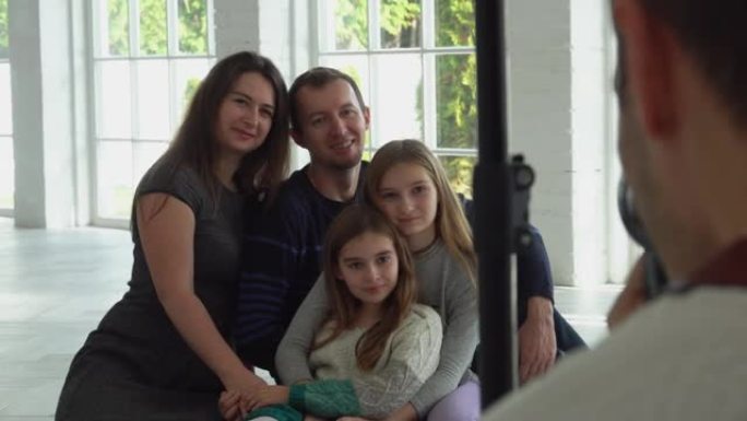 摄影师正在与两个兄弟姐妹一起拍摄一个幸福的家庭的照片