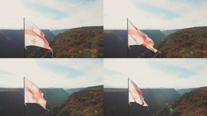 格鲁吉亚撕裂的旗帜在蓝色晴朗的天空背景下以慢动作挥舞。复古过滤器背景