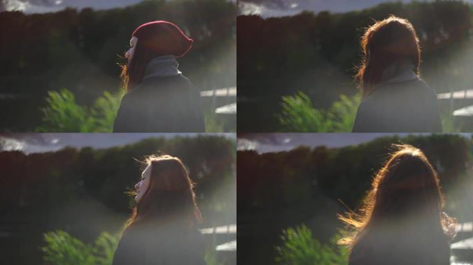 女人在湖边脱下帽子。风长出红头发