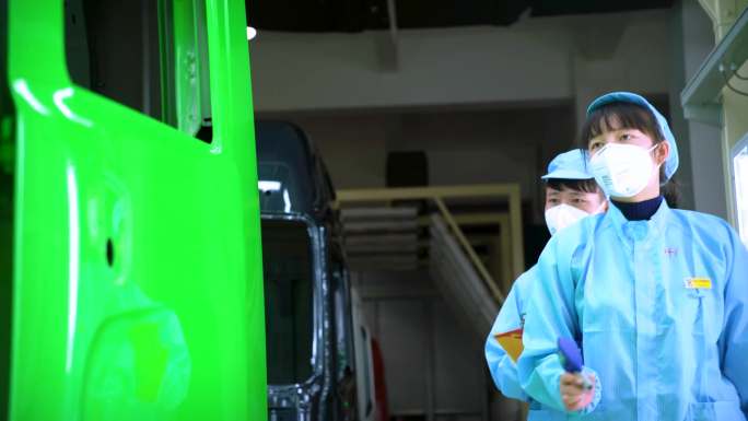喷漆 一名男子站在工厂的汽车前 工厂里的卡车图片