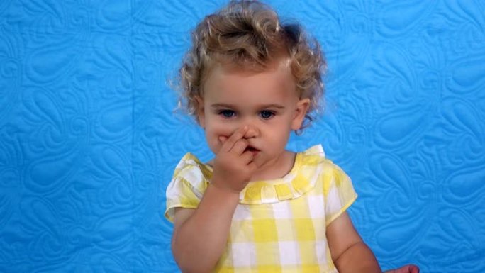 小女婴用手指露出鼻子、眼睛、耳朵、嘴巴、舌头
