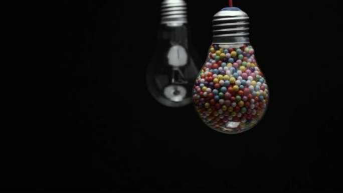 灯泡充满彩色球黑色背景。宏观观。