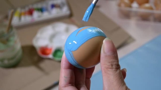慢动作，人们用毛笔在鸡蛋工艺品上画蓝色，为复活节快乐做准备