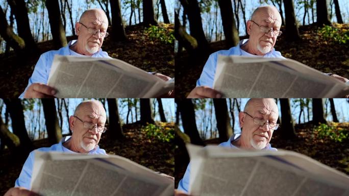积极退休，老人留着胡须，戴着眼镜在公园里看报纸。