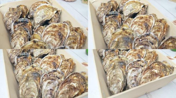 在4k的桌子上打开一个装满新鲜苏格兰牡蛎的木箱。