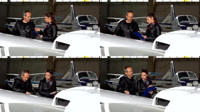 飞行教练和学生飞行员在机库的飞机上进行目视检查