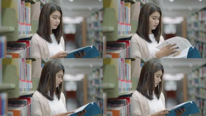 聪明的亚洲人大学生在带复制空间的校园图书馆书架之间阅读书籍。