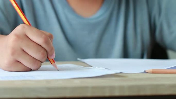 大学或高中的教育考试概念: 用手拿着铅笔在答题纸上测试考试，在校园教室填写考试文件。知识学习理念