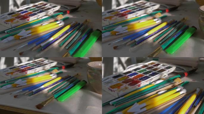 艺术家工作室的桌面上有许多用于绘画和调色板的画笔