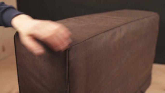 男子双手在沙发上拉紧皮布的特写镜头。家具厂制造的沙发，木工师傅触摸软垫