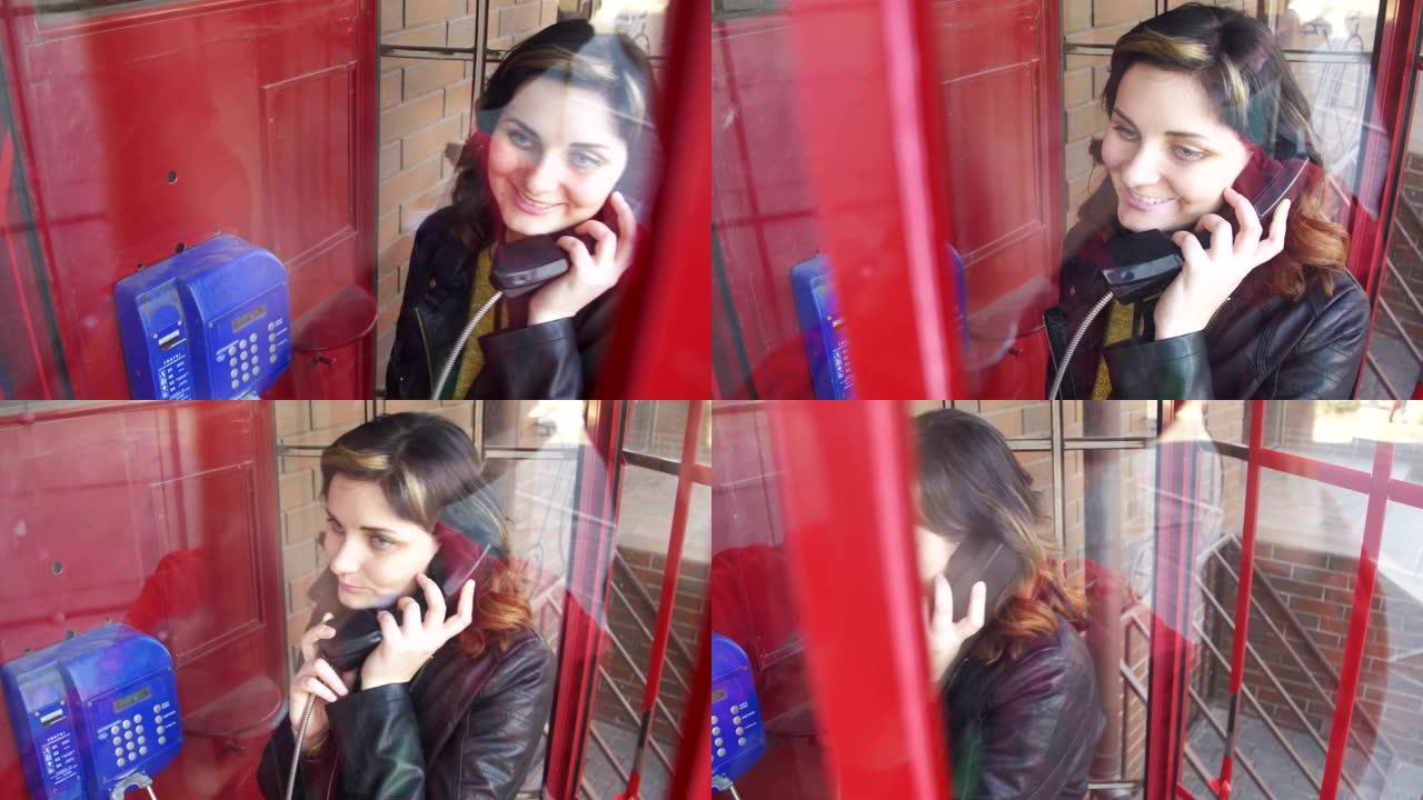 红色电话亭里的快乐女孩在街上打电话