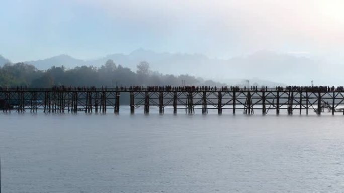 游客人群在 “Saphan Mon” 的木桥视点上晨雾背景。泰国北碧府。