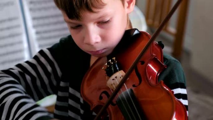 8岁的男孩正在拉小提琴。